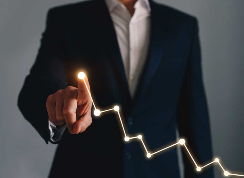 A business professional pointing at a graph.