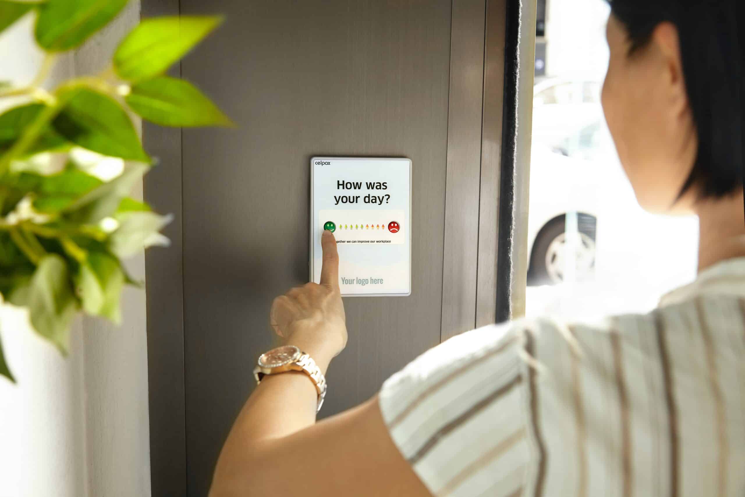 A woman pressing a button on a door to open it.