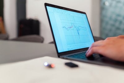 A person is using a laptop with a graph on it.
