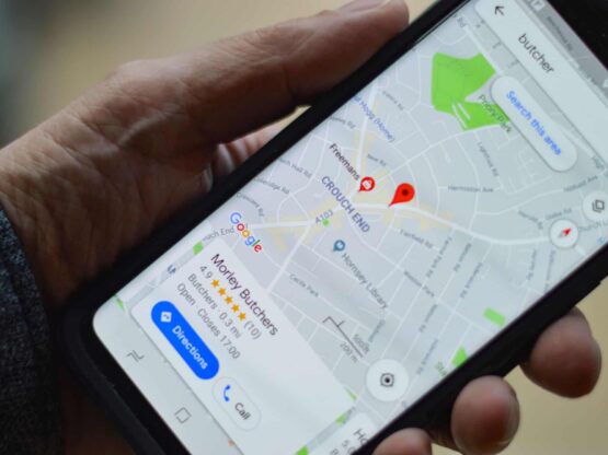 A person holding a cell phone with Google Maps displaying reviews.