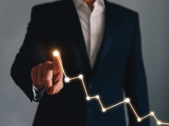 A business professional pointing at a graph.